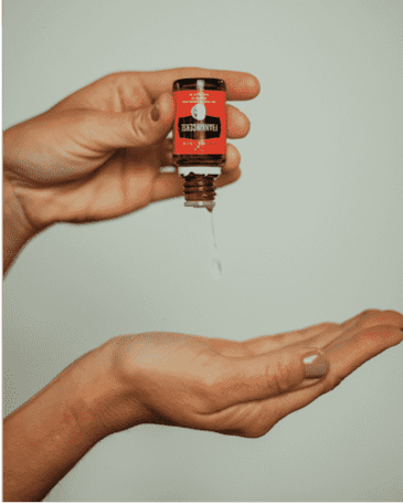 Woman pouring essential oils onto her hand Woman pouring essential oils onto her hand