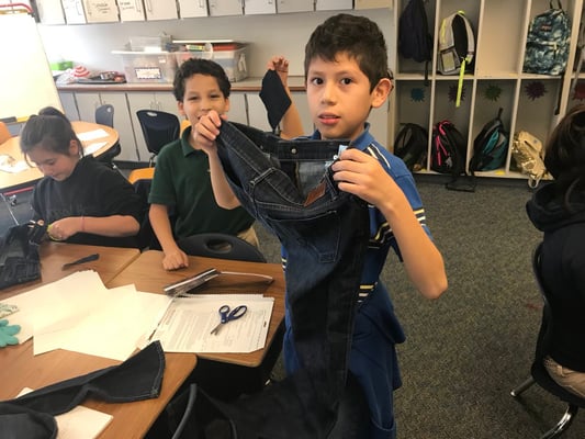 Elementary student holding jeans