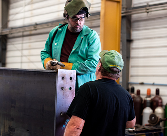 welder and worker in steel shop