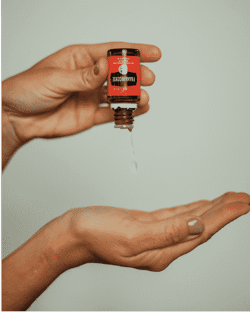 Woman pouring essential oils onto her hand