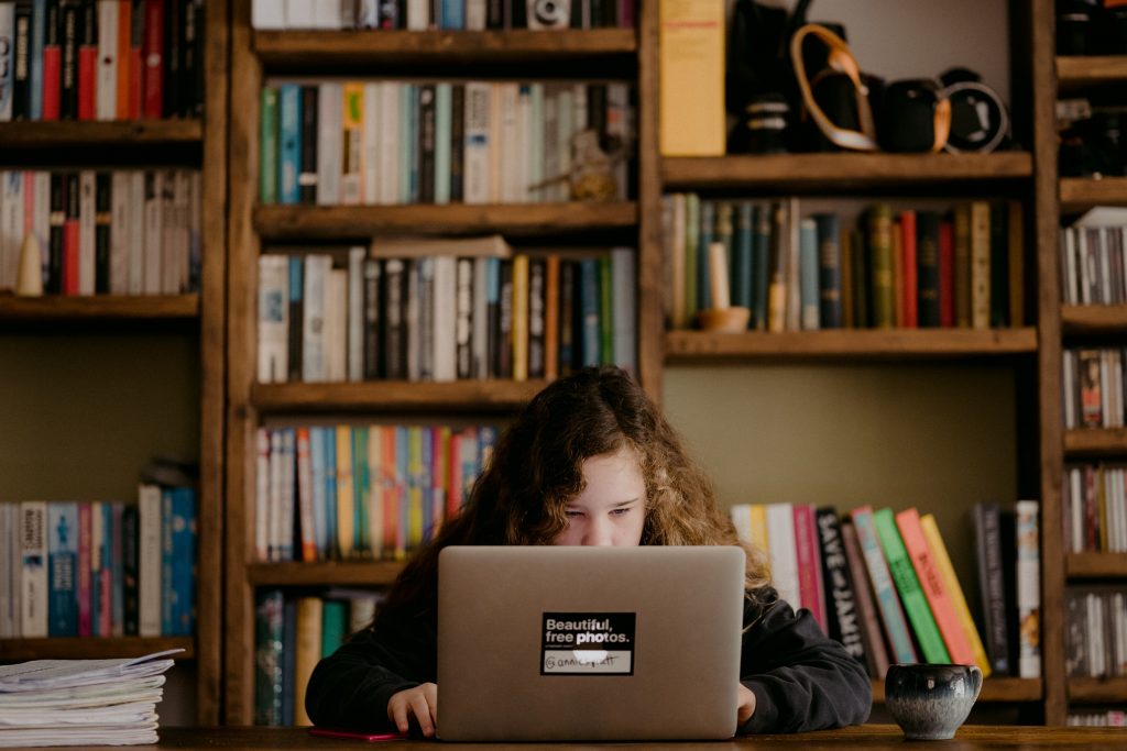 Na imagem, vemos uma estudante com motivação para estudar em seu computador.