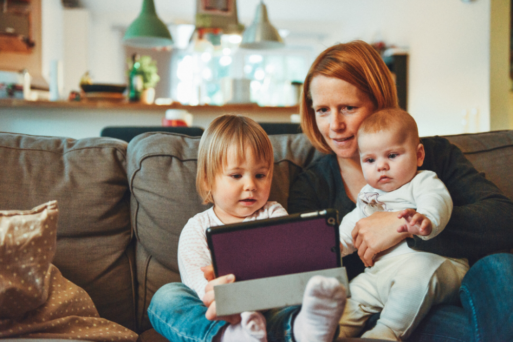 Mãe e filhos fazendo atividades para crianças no tablet