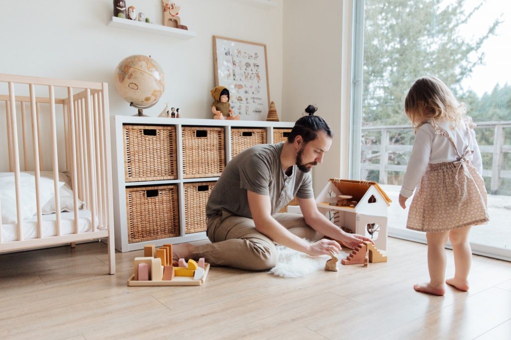 Um pai e sua filha brincam juntos como uma forma desenvolver atividades para aproximar pais e filhos em casa.