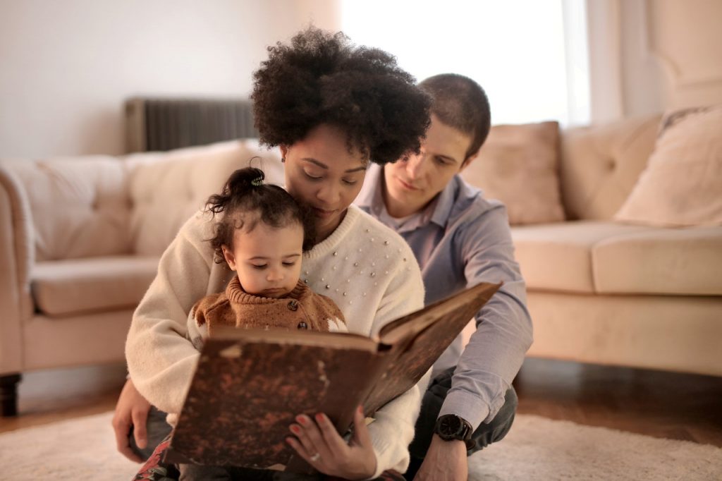 Uma família compartilha uma leitura como uma forma de atividades para aproximar pais e filhos em casa