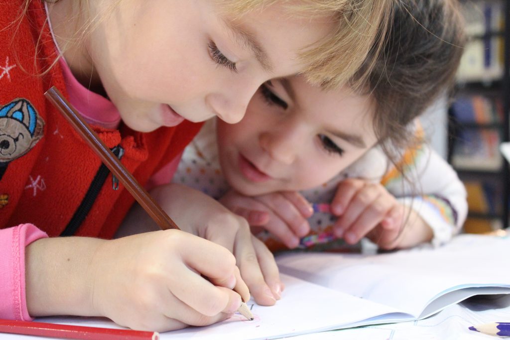 Duas crianças praticando a aprendizagem colaborativa.
