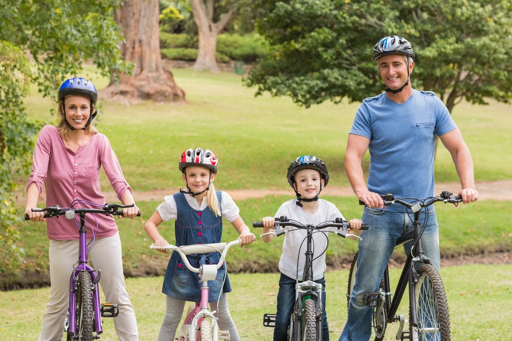 Happy family on their bike at the park on a sunny day