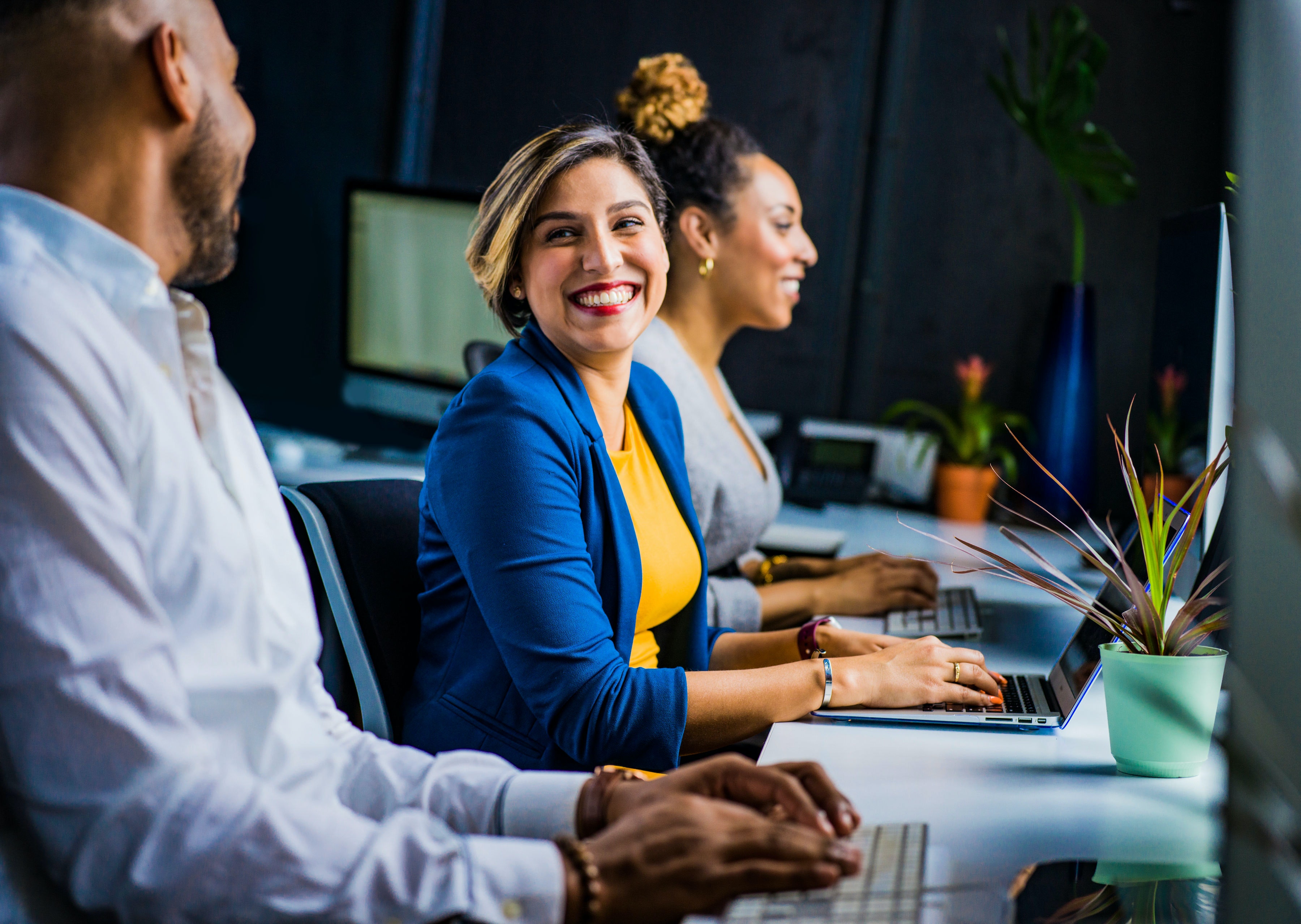 Grupo de personas trabajando y sonriendo