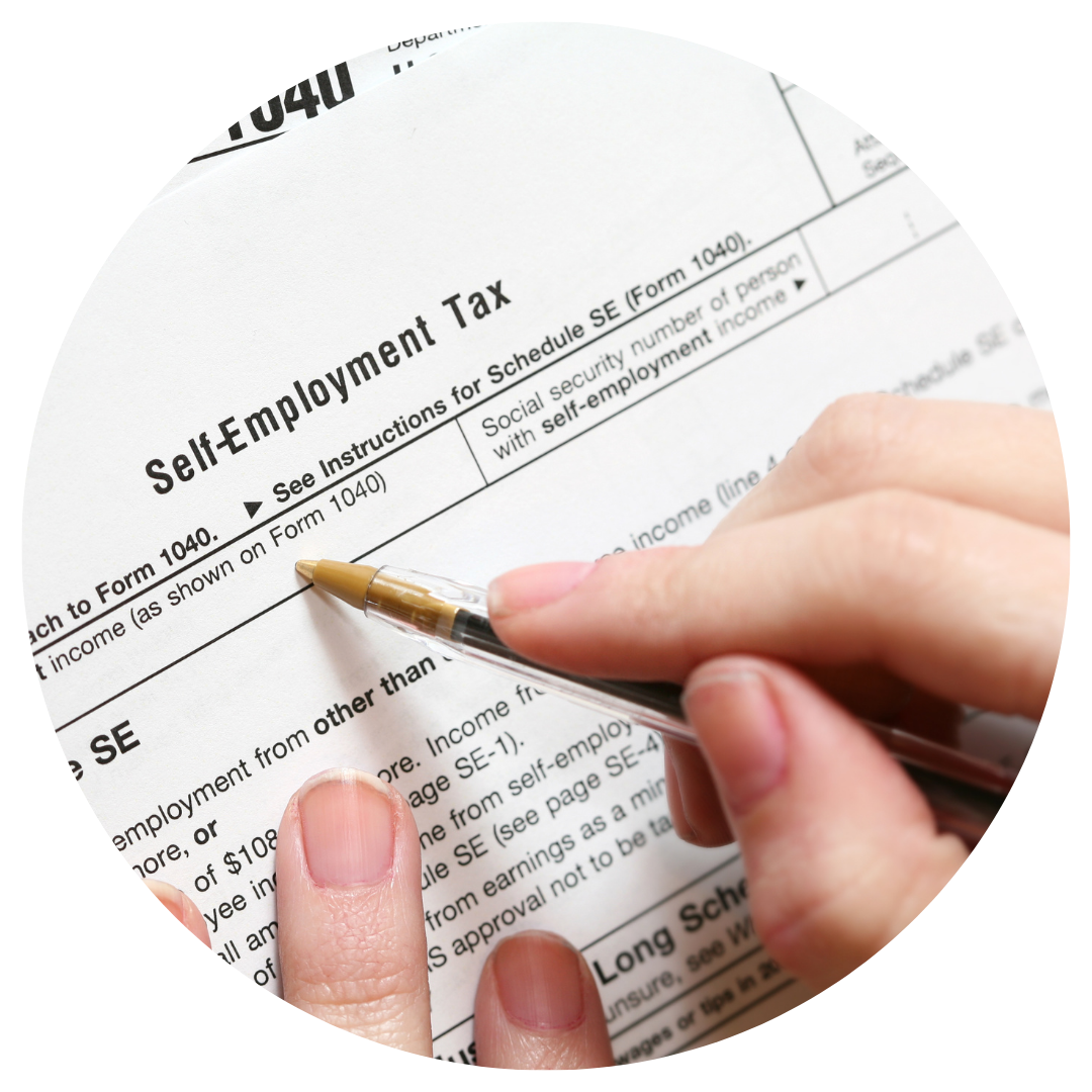 self employment tax form and person holding pen