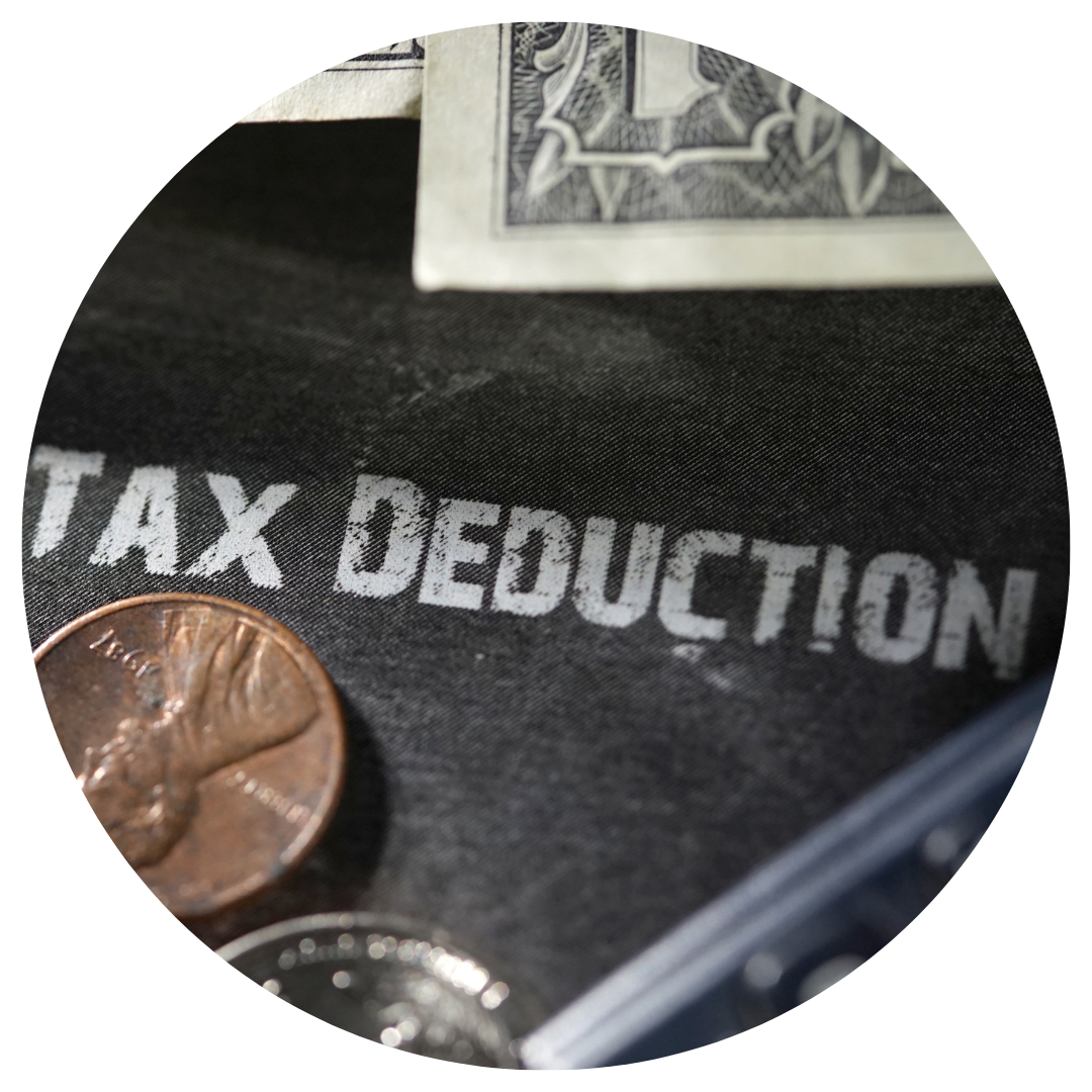 tax deduction written on black background with coins around it 