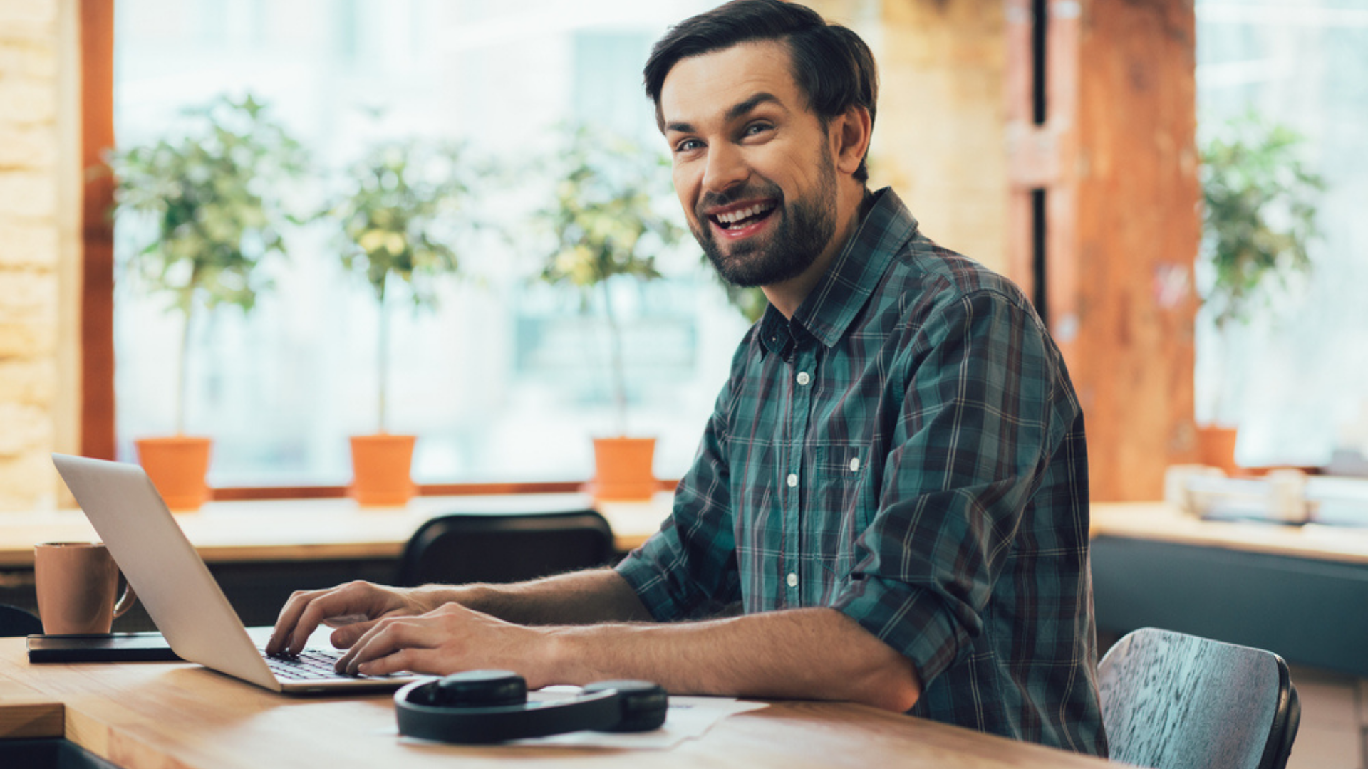 millenial man working with his laptop and a coffee on app development