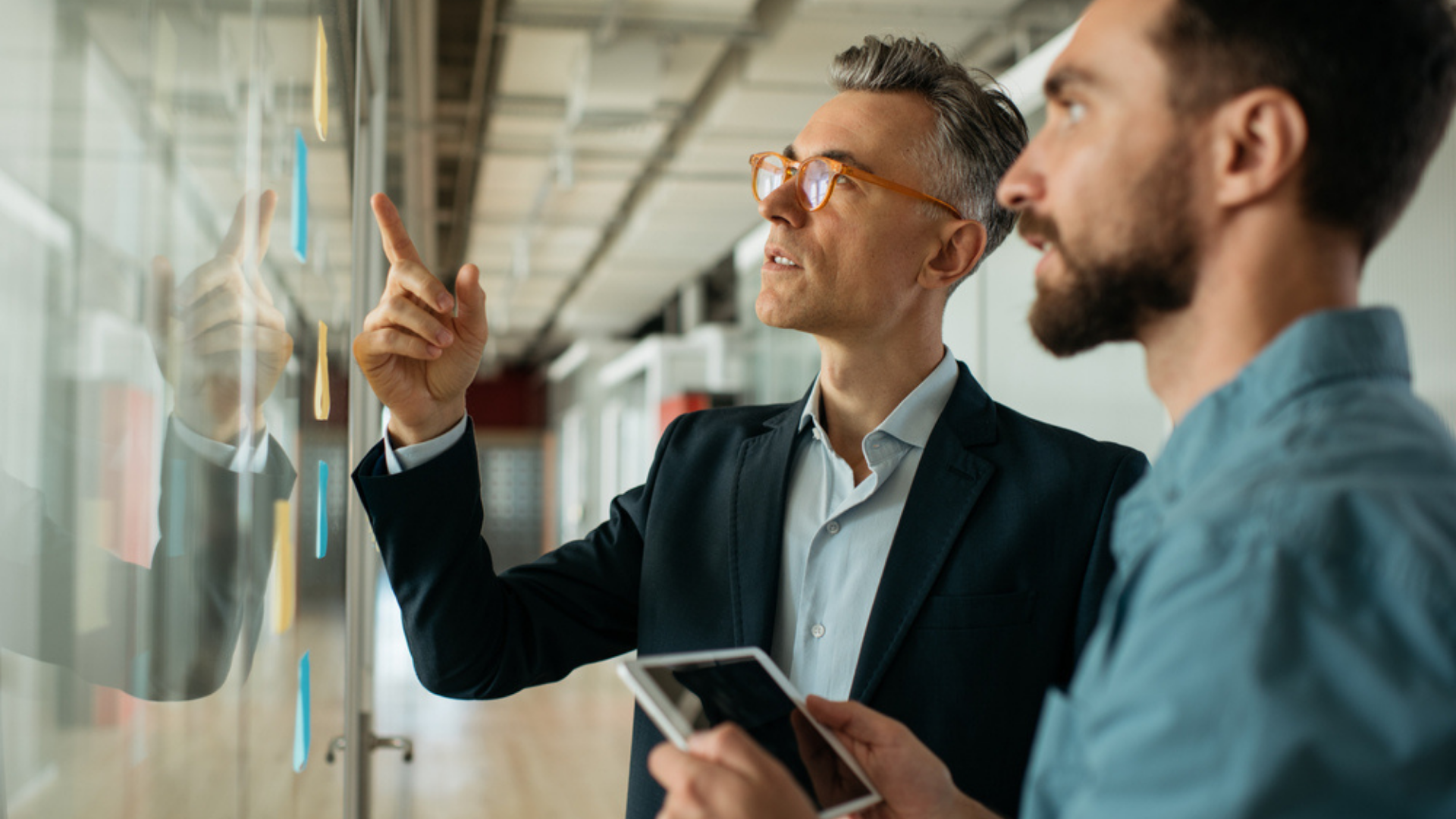 two men at work reviewing an unfinished task, implementing agile methodologies