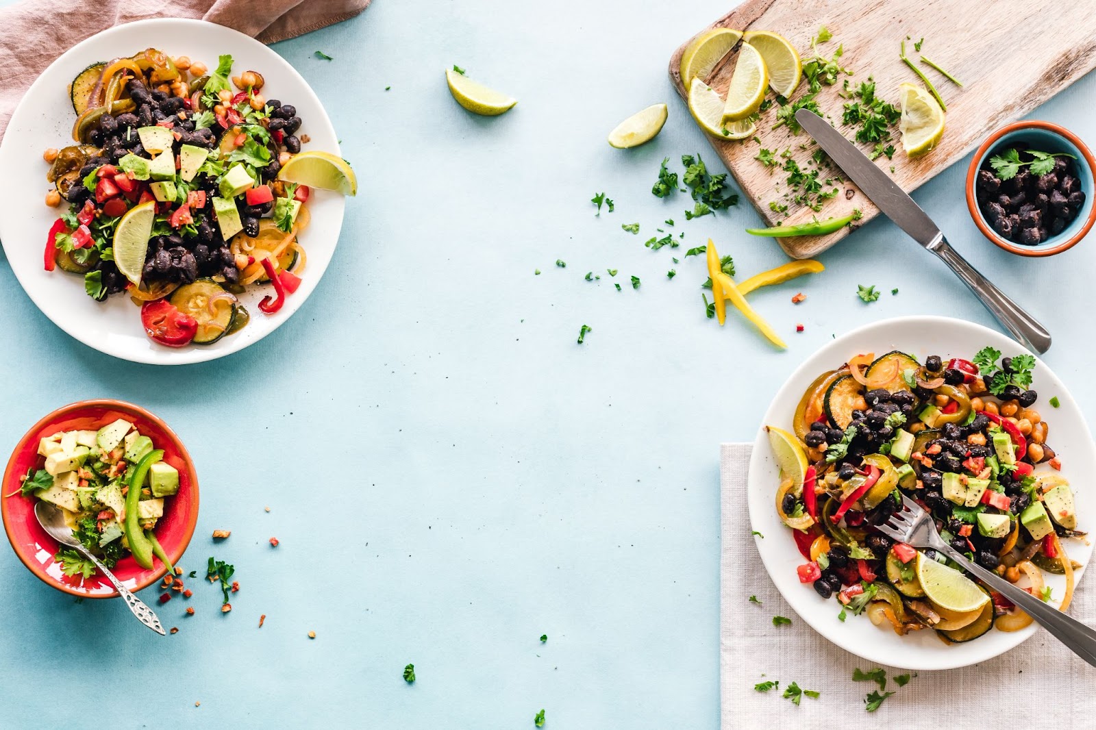 Plates of fruit and vegetable dishes on a blue table