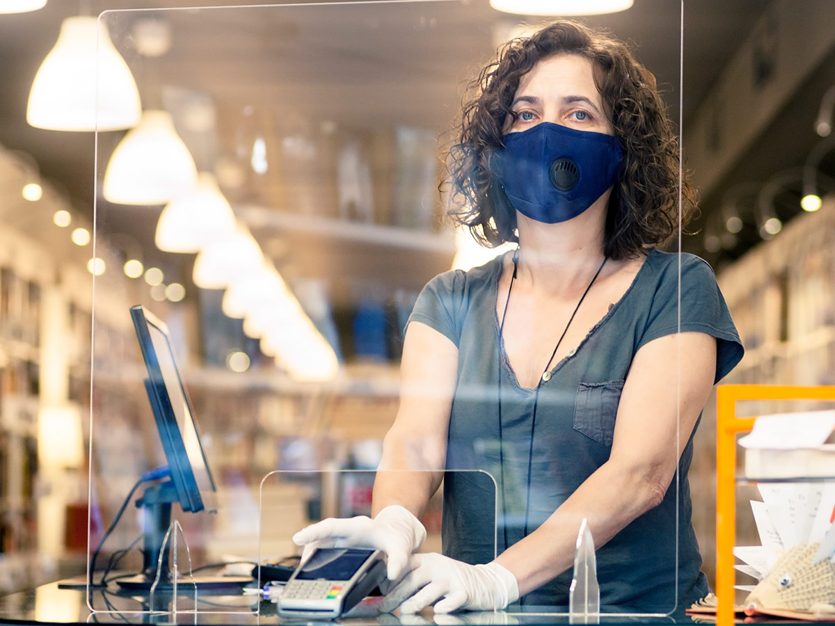 A woman in a mask and protective gloves holding the terminal